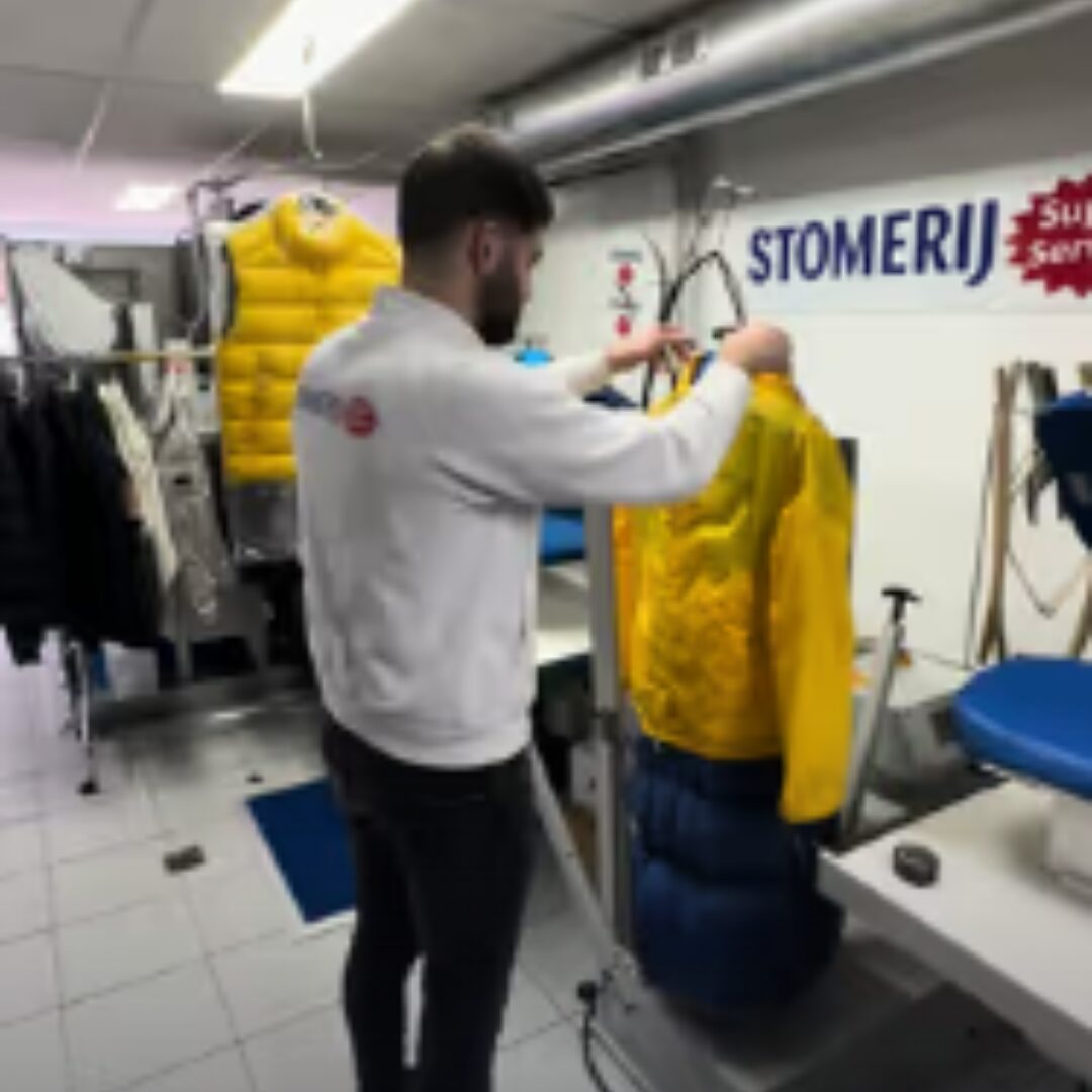 Medewerker werkt een gele jas af in de werkplaats